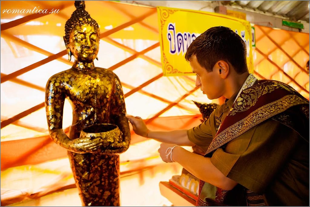 A groom pays respect to Buddhist saints during a wedding ceremony at a Buddhist temple