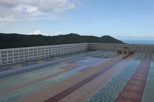 Hochzeitszeremonie auf dem Dach eines Hotels mit Blick auf den Ozean Für viele stehen auf der thailändischen Insel Koh Samui vor allem Strände und das azurblaue Meer im Mittelpunkt. Es gibt jedoch Orte, die in keinem Reiseführer erwähnt werden, über die Ihnen die Reiseführer nichts sagen, und die Sie auf der Karte nicht finden. In den Bergen von Lamai können Sie stundenlang auf Hunderten von kurvenreichen Straßen fahren und anhalten, um sich die Palmenhaine, Durianbäume und Bananen anzusehen, die direkt am Straßenrand wachsen. An Ihrem Hochzeitstag möchten Sie nicht ständig Dutzende von Gesichtern und Hunderte von zusätzlichen Menschen sehen und Toasts und lauter Musik lauschen. Wer Privatsphäre und Intimität bevorzugt, kann ein abgelegenes kleines Hotel in den Bergen wählen, mit Blick auf die gesamte Insel, das Meer und unzählige Kokospalmen. Ein Ort, an dem außer Ihnen beiden fast niemand da ist, Vögel über Ihnen fliegen und etwas in ihrer eigenen Sprache singen, Kerzen bei Sonnenuntergang flackern und Sie stundenlang im Schatten eines Mangobaums sitzen können. Dieser Ort fasziniert durch seine Ursprünglichkeit und Romantik. Auf dem terrassenförmig angelegten Dach des Hotels können Sie nicht nur unter dem Mond tanzen, sondern auch ein wunderbares, speziell für Sie zubereitetes Abendessen genießen. Hier gibt es keinen Pomp und keine Routine, hier lebt alles, aber es lebt nach den Gesetzen der Natur – Leben um des Lebens willen! Wenn Sie dieses Stück Paradies für Ihre Zeremonie gewählt haben, werden Sie spüren, wie die Wolken in Ihrem Haar spielen und Minuten zur Ewigkeit werden.